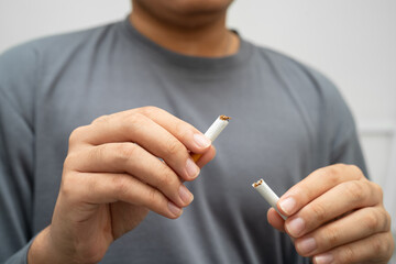 Quit smoking, Asian teenage man breaking destroy cigarette in hand.