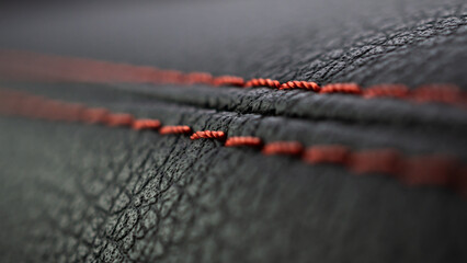 Red stitch on black leather of luxury sports car