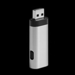 A sleek silver usb flash drive stands upright against a stark black background in studio shot