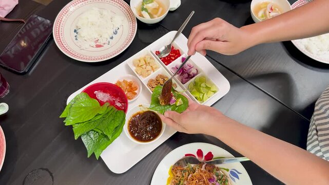 Assembling Miang Kham Savory Leaf Wraps at Dining Table