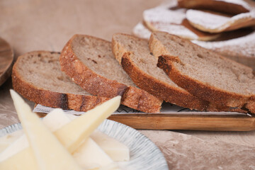 Freshly sliced bread served with cheese on a wooden platter