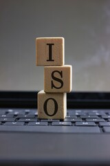 Stacked Wooden Blocks Displaying the ISO Letters on a Laptop Keyboard