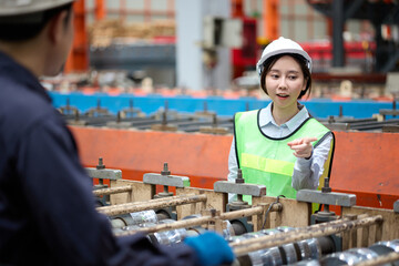 Engineer or worker talking and meeting with coworker in the metal sheet factory