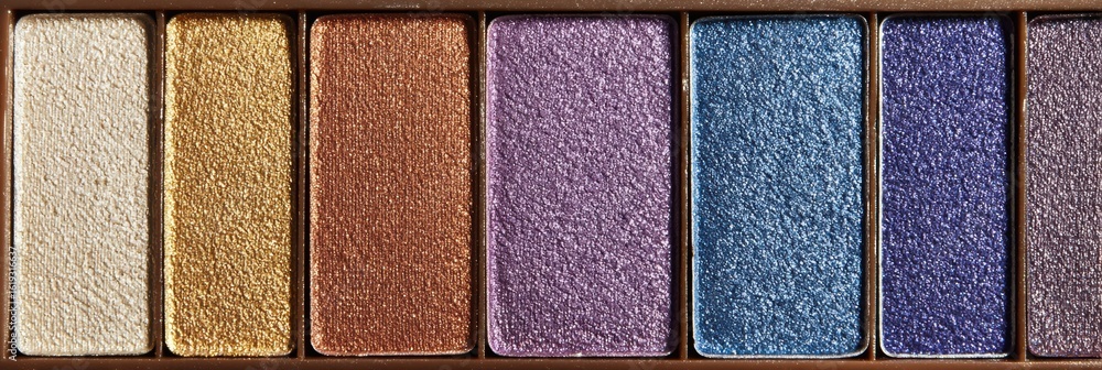 Poster collection of shimmering eyeshadow pans arranged with diffused light creating an appealing, colorful