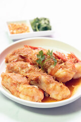 A delicious plate of fried shrimp garnished with herbs, served with side sauces for a tempting culinary experience.