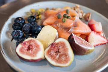 A vibrant plate of fresh fruits including figs, berries, and melon, presenting a colorful and healthy snack option.