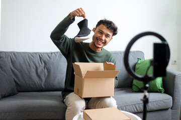 Happy Male Influencer Holding Up New Sneaker From Box For Online Video Review