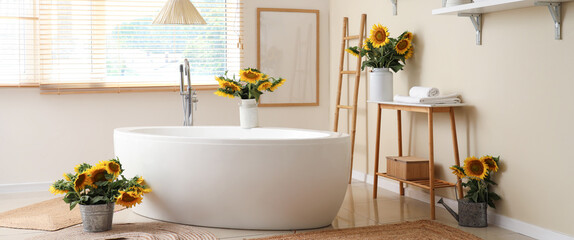 Vases with beautiful sunflowers in interior of bathroom