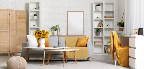 Vase with sunflowers on coffee table in stylish living room
