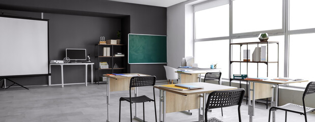 Interior of empty classroom with desks and chalkboard