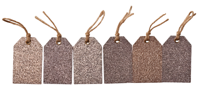 Brown glittery tags arranged on a light wooden surface