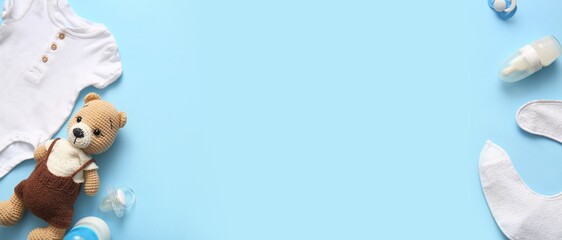 Baby clothes, accessories and toy on blue background with space for text