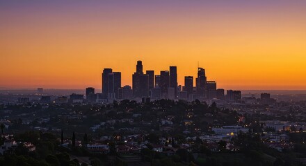 City skyline silhouette against a vibrant orange and purple sky at twilight hour in los angeles area