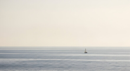 Naklejka premium Serene sailboat glides across calm ocean waters under pale sky