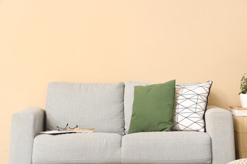 Cozy sofa with cushions and glasses in living room