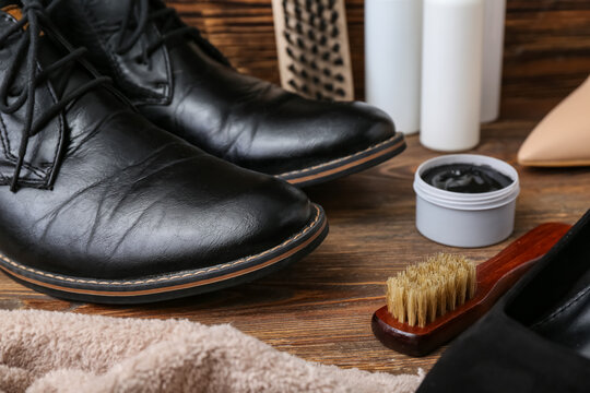 Shiny shoes, cloth, brushes and shoe polish on wooden background - Powered by Adobe