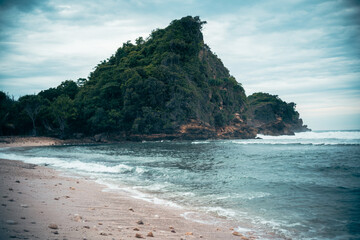 view of hills, trees and sea waves on the beach sand under the blue sky 1