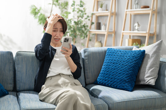 スマホを見て悩む女性