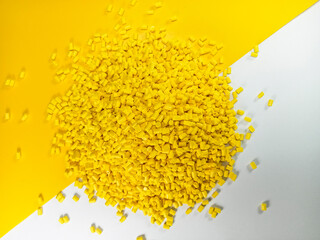 Yellow masterbatch plastic granules, polymer carries colorful pigments poured into a yellow...