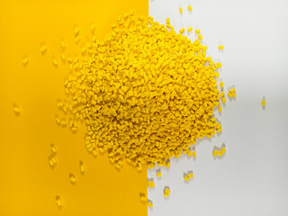 Yellow masterbatch plastic granules, polymer carries colorful pigments poured into a yellow...