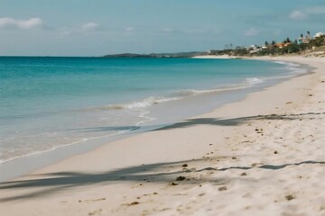 Wide Sandy Beach with Gentle Waves and Dunes under Clear Blue Sky