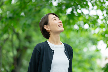 新緑の中に立つ女性