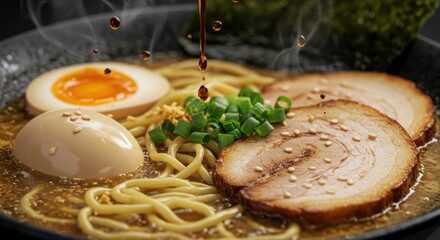 A close up of ramen with pork slices, egg, and green onions with sauce being poured on top