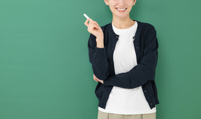 黒板の前に立つチョークを持った女性