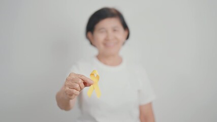 Elderly with Yellow Ribbon for concept of yellow September, Suicide prevention day, Childhood, July Sarcoma, bone and bladder cancer Awareness month, support survivor. Healthcare and World Cancer day