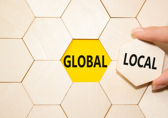 Global and Local symbol. Concept word Global and Local on wooden comb puzzle. Businessman hand. Beautiful yellow background. Business and Global and Local concept. Copy space