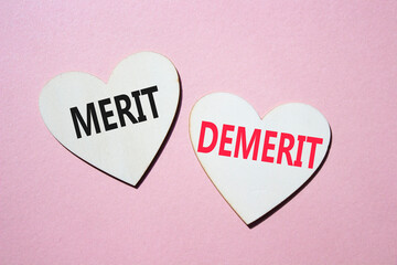 Merit or Demerit symbol. Concept word Merit or Demerit on wooden hearts. Beautiful pink background. Business and Merit or Demerit concept. Copy space