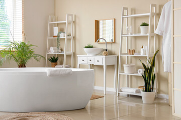 Interior of modern stylish bathroom with hanging bathrobe
