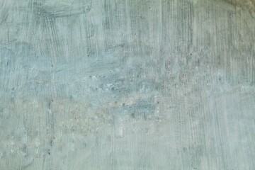The dull, cracked gray walls of an old building are affected by the weather.