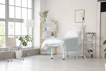 Interior of hospital ward with bed, drip infusion and shelf unit