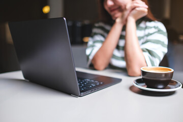 Closeup image of a woman working on laptop computer in cafe