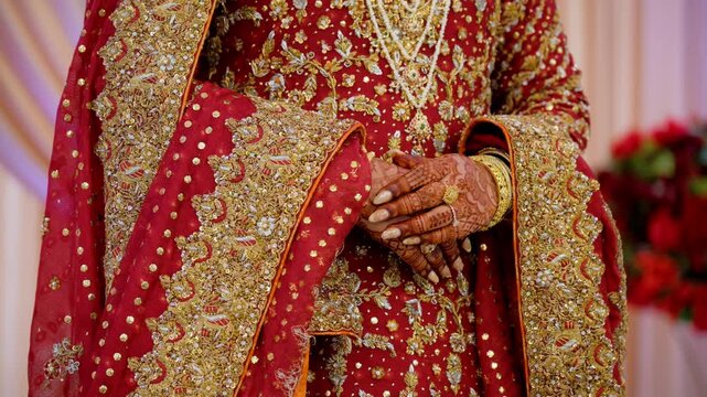 Bride is keeping her hands in traditional manner, dressed in red traditional Indian clothes, Elements of hindu wedding. 