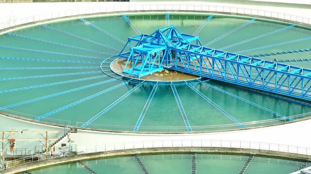 Bird's eye view of a wastewater treatment facility with circular clarifiers and rectangular filtration basins, showcasing critical infrastructure for effective water purification and community health.