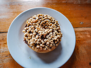 Chocolate peanut flavor donut, served in a white plate, top view