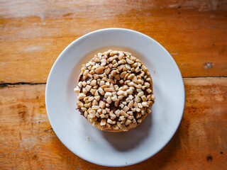 Chocolate peanut flavor donut, served in a white plate, top view