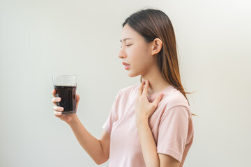 Acid reflux disease, suffer asian young woman, girl hand holding a glass of cola, have symptom...
