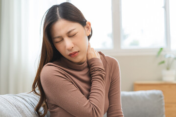 Pain body muscles stiff problem, suffer asian young woman, girl painful with back, holding neck ache from work hand holding massaging rubbing shoulder hurt, sore sitting on couch at home. Health care