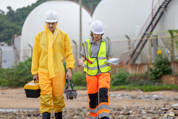 Environmental Engineers Inspecting Water Quality at Industrial Site, Scientists at a Coastal Processing Plant, Petrochemical Facility Workers with Tools and Laptop