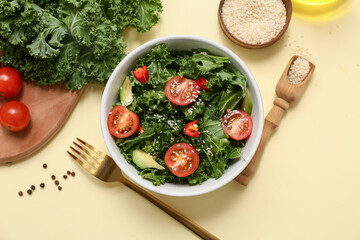 Bowl of tasty kale salad with tomatoes, avocado and sesame seeds on color background