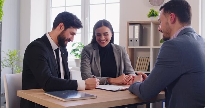 Happy family couple have meeting in office with real estate agent, closing deal or agreement, signing contract, going to become new ownerships, buy their first house. Mortgage negotiating