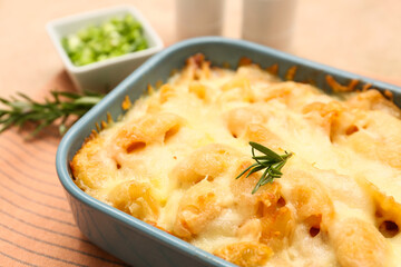 Baking dish with tasty pasta, rosemary and cheese, closeup