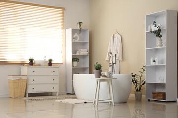 Interior of modern bathroom with different houseplants and pots of lavender flowers