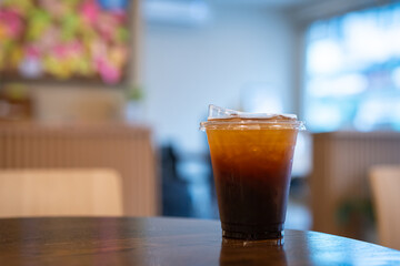 Close-up of Americano ice coffee or black coffee in cup mug on  wood desk office desk in coffee shop at the cafe in garden,during business work concept