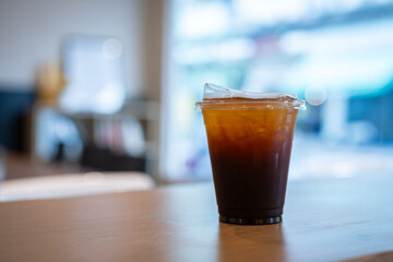 Close-up of Americano ice coffee or black coffee in cup mug on  wood desk office desk in coffee shop at the cafe in garden,during business work concept