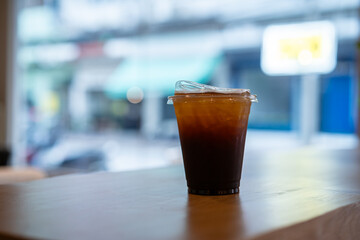 Close-up of Americano ice coffee or black coffee in cup mug on  wood desk office desk in coffee shop at the cafe in garden,during business work concept