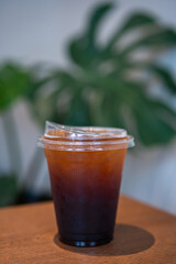 Close-up of Americano ice coffee or black coffee in cup mug on  wood desk office desk in coffee shop at the cafe in garden,during business work concept